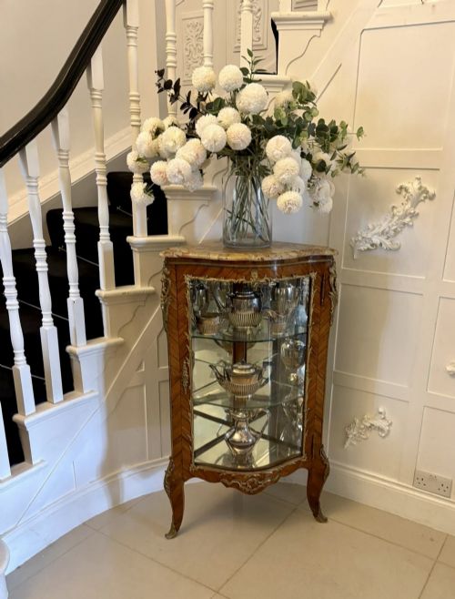 fig 2. An antique French serpentine corner display cabinet crafted from kingwood with a marble top, curved glass door, internal glass shelves, and gilded ormolu mounts.