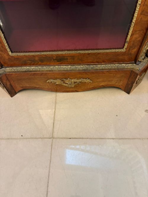 fig 2. A pair of Victorian burr walnut pier cabinets featuring glazed front doors, velvet-lined interior shelves, and ornate gilt metal mounts.
