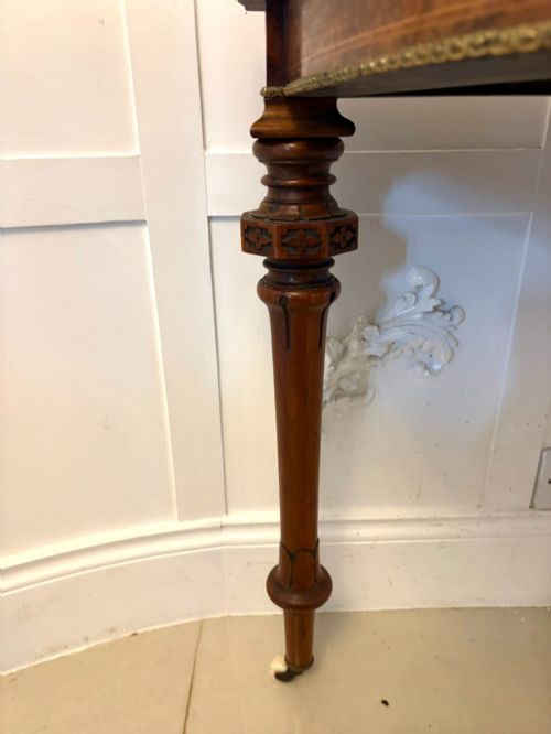 fig 1. A Victorian burr walnut fold-over card table featuring geometric inlay, turned support legs on castors, and decorative brass edge moulding.