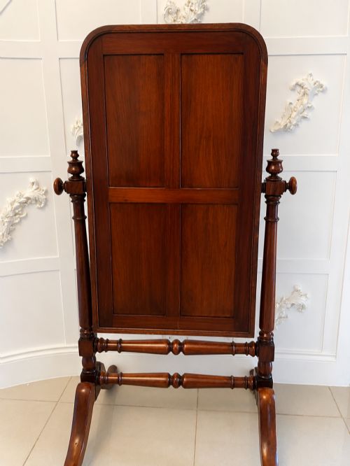 fig 1. A Victorian mahogany freestanding cheval mirror featuring turned upright pillars, arched legs, and a swivelling full-length mirror frame.