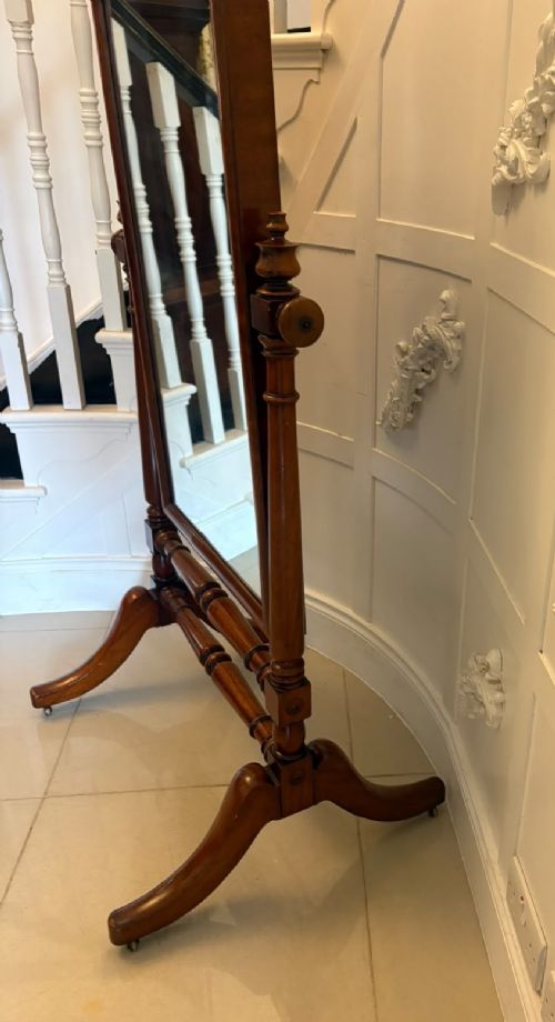 A Victorian mahogany freestanding cheval mirror featuring turned upright pillars, arched legs, and a swivelling full-length mirror frame. View IX
