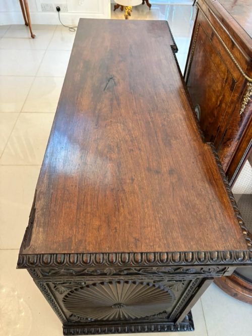 fig 1. A Victorian burr walnut credenza featuring a central oval mirrored door flanked by curved bow-front glass doors and gilt ormolu mounts.