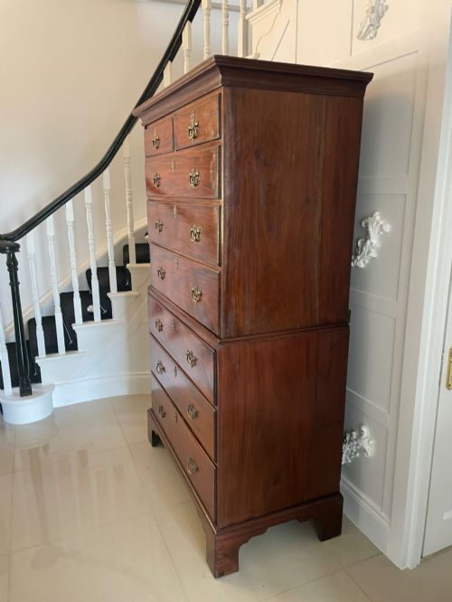 fig 3. An antique Georgian mahogany chest on chest featuring eight drawers with brass swan-neck handles, keyhole escutcheons, and bracket feet.