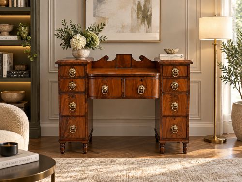 fig 1. A Regency flame mahogany kneehole desk featuring twin pedestals with multiple drawers, brass ring handles, turned feet, and a shaped back gallery.