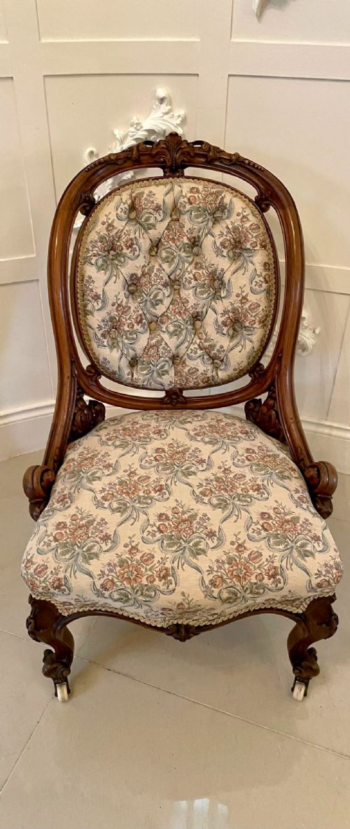 A pair of Victorian carved walnut side chairs featuring button-tufted floral upholstery and cabriole legs with ceramic castors. View XII
