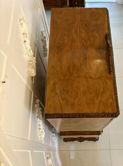 An antique burr walnut cocktail cabinet featuring two upper doors with ornate brass hardware, set on carved cabriole legs. View IV