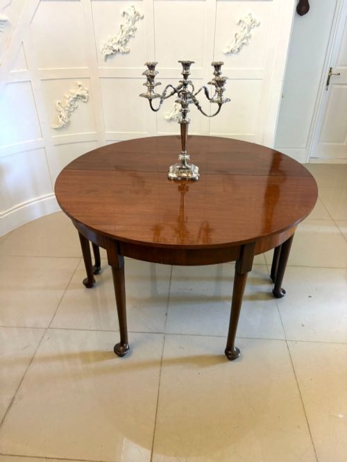 fig 1. A large extended Georgian mahogany dining table featuring curved D-shaped ends, polished figure top, and slender legs with pad feet.