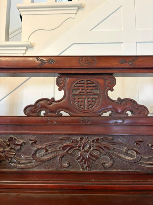 fig 2. A carved reddish-brown hardwood display cabinet featuring a pagoda cresting, glass door, asymmetrical interior shelves, lower drawers, and cabriole legs.