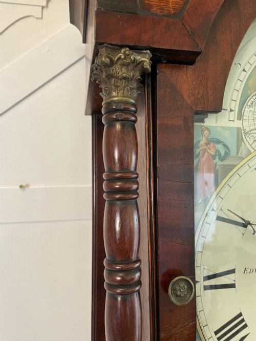 fig 1. An antique George III oak and mahogany longcase clock with a swan-neck pediment, reeded columns, and a painted moon phase dial.