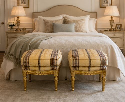 fig 1. A pair of square French style footstools featuring carved gold giltwood frames, fluted legs, and yellow patterned upholstery.