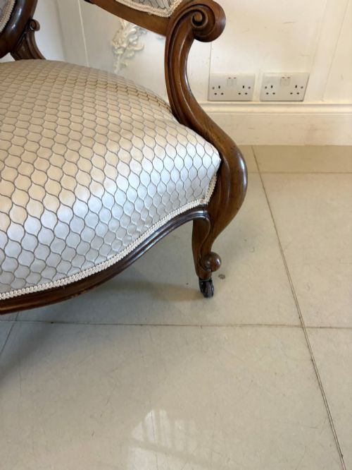 fig 4. An eleven-piece antique Victorian carved walnut salon suite featuring a central sofa, pair of armchairs, six side chairs, and two footstools, all upholstered in a patterned cream fabric.