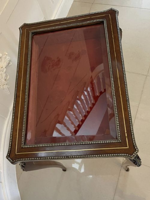 A 19th-century French mahogany bijouterie display table featuring a glazed top with brass inlay, a single front drawer, and slender cabriole legs with brass mounts. View IV