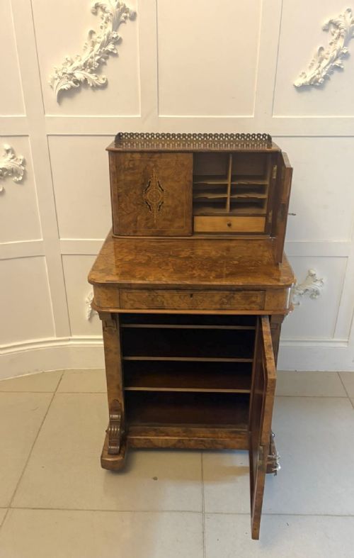 A Victorian burr walnut Davenport desk with floral marquetry inlay, a brass top gallery, and carved scroll feet. View VII