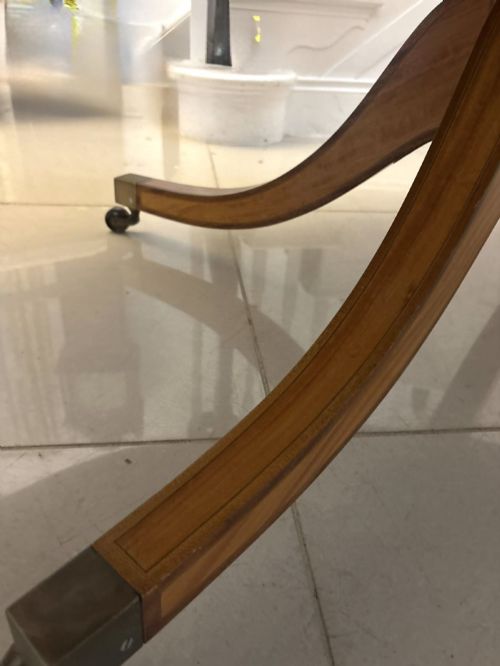 fig 1. An antique Regency style oval mahogany tilt-top dining table featuring a figured timber top with satinwood crossbanding mounted on a pedestal base with brass castors.