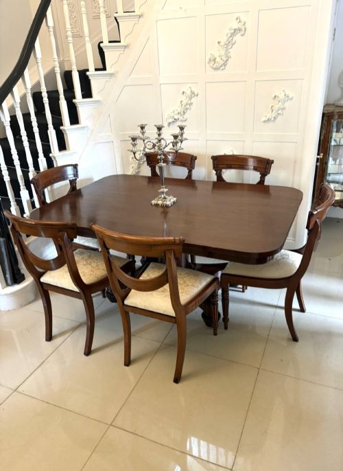 fig 1. A William IV figured mahogany tilt top dining table shown upright, featuring rounded corners, a smooth grain finish, and a central pedestal base with carved feet.