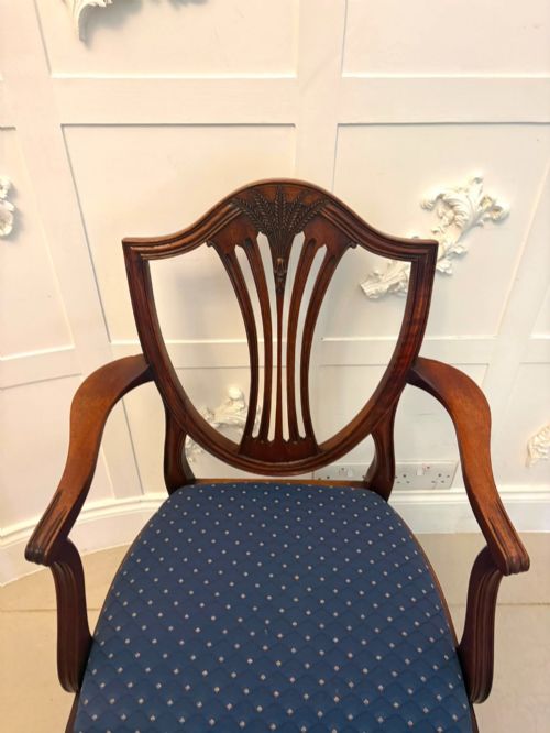 fig 3. A set of twelve mahogany shield back dining chairs featuring carved backrest splats, square tapered legs, and blue patterned upholstered seats.