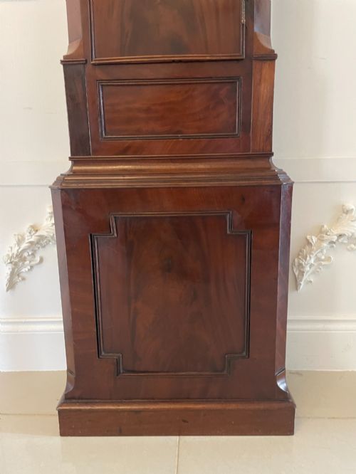 fig 3. A George III flame mahogany longcase clock featuring a swan-neck pediment, turned hood columns, a painted arch dial, and a gothic-arched trunk door.