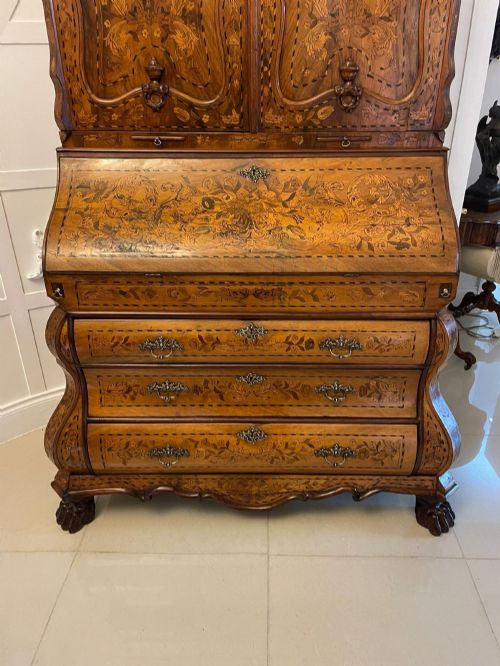 fig 1. An 18th-century Dutch burr walnut bureau bookcase featuring intricate floral marquetry, a bombe lower drawer section, a fall-front desk slope, and an arched twin-door upper cabinet supported on claw feet.
