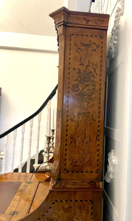 An 18th-century Dutch burr walnut bureau bookcase featuring intricate floral marquetry, a bombe lower drawer section, a fall-front desk slope, and an arched twin-door upper cabinet supported on claw feet. View X