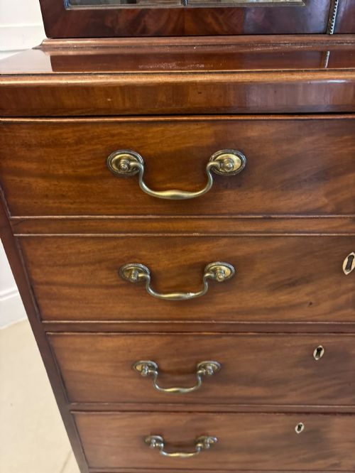 fig 3. A tall Georgian mahogany secretaire bookcase featuring an upper cabinet with astragal glazed doors and a lower chest of drawers with brass handles.