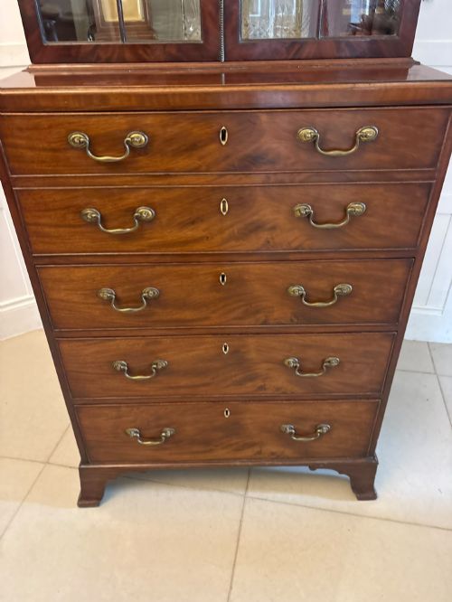 fig 4. A tall Georgian mahogany secretaire bookcase featuring an upper cabinet with astragal glazed doors and a lower chest of drawers with brass handles.