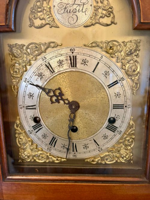 fig 1. An Edwardian mahogany longcase clock with satinwood urn inlay on the door and a brass dial with Tempus Fugit inscription.