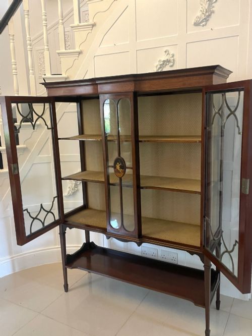 fig 1. An Edwardian mahogany display cabinet featuring glazed doors with astragal bars, a central marquetry inlay medallion, tapering square legs, and an undertier shelf.
