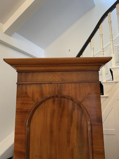 A William IV mahogany breakfront wardrobe featuring two tall outer cupboards flanking a central chest of three drawers with a carved gallery back. View IV