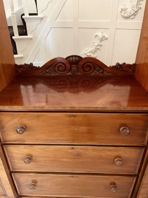 A William IV mahogany breakfront wardrobe featuring two tall outer cupboards flanking a central chest of three drawers with a carved gallery back. View VI