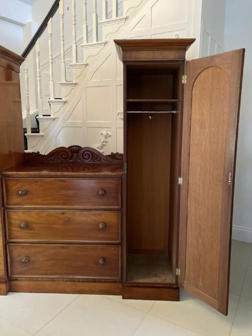 A William IV mahogany breakfront wardrobe featuring two tall outer cupboards flanking a central chest of three drawers with a carved gallery back. View VIII