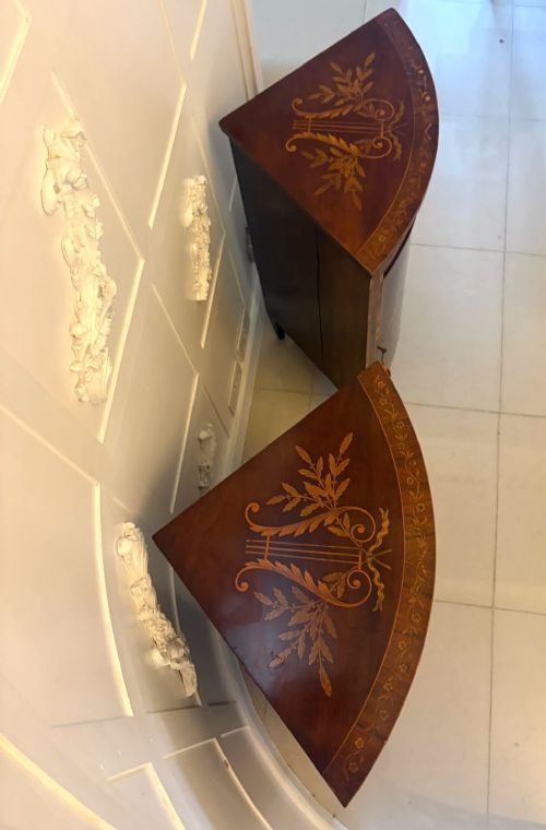 fig 3. A pair of Victorian mahogany corner cabinets featuring curved bow fronts with floral urn marquetry inlays and tapered square feet.
