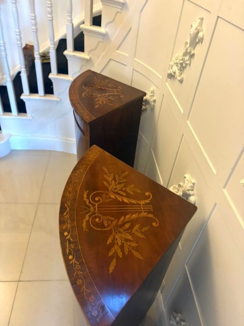 fig 4. A pair of Victorian mahogany corner cabinets featuring curved bow fronts with floral urn marquetry inlays and tapered square feet.