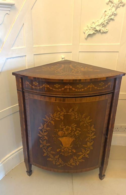 A pair of Victorian mahogany corner cabinets featuring curved bow fronts with floral urn marquetry inlays and tapered square feet. View XV