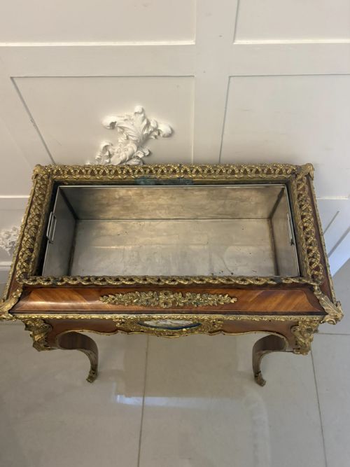 fig 3. A Louis XV style kingwood jardiniere stand with ornate gilt-bronze ormolu mounts, cabriole legs, and a central porcelain plaque.