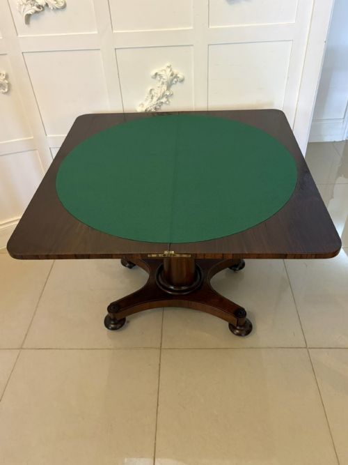 fig 1. A Regency rosewood card table featuring fine brass inlay stringing, a fold-over swivel top, a central pedestal stem, and a quadform base on round feet.