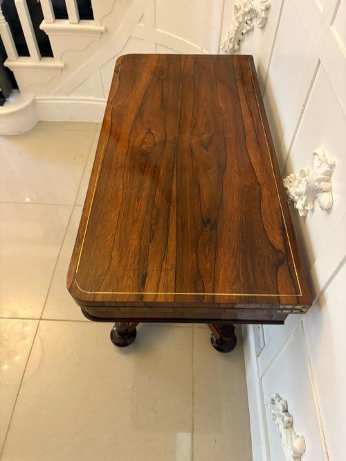 fig 4. A Regency rosewood card table featuring fine brass inlay stringing, a fold-over swivel top, a central pedestal stem, and a quadform base on round feet.
