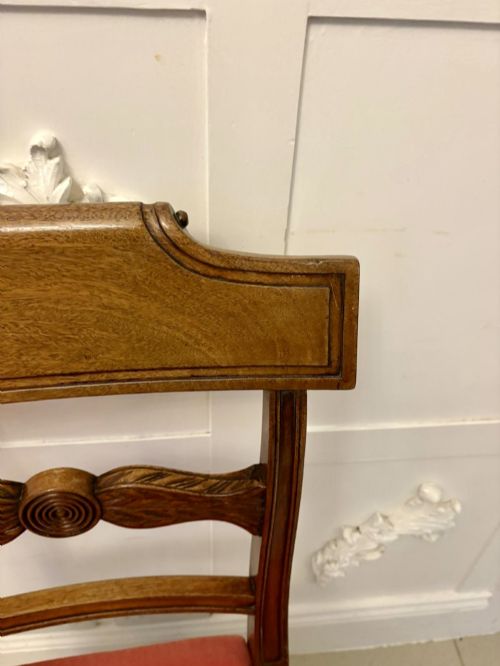 fig 5. A set of twelve Regency mahogany dining chairs with carved mid-rails and coral fabric upholstered seats, including two matching carver armchairs.