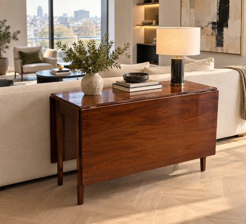fig 1. An antique Georgian mahogany drop-leaf dining table shown folded closed with square straight legs and a polished dark wood surface.