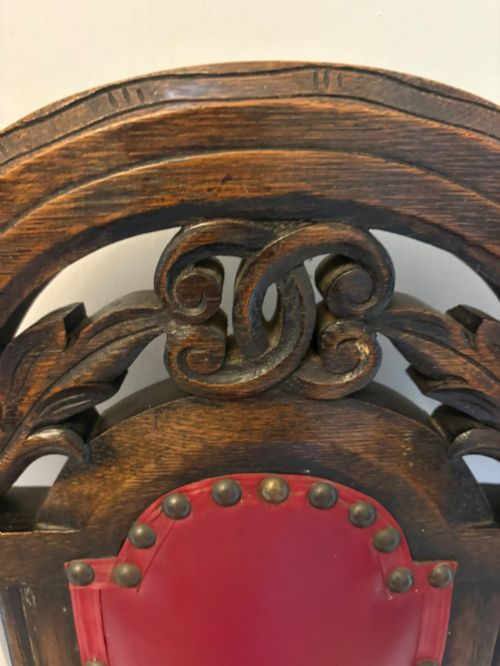 fig 1. A set of high-backed dark oak dining chairs with barley twist uprights, carved cresting rails, and red upholstered seats and back panels with stud trim.