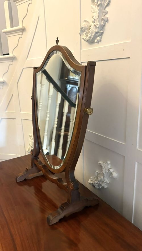 An Edwardian mahogany toilet mirror featuring a shield-shaped frame with bevelled glass mounted on a swivelling stand with brass knobs. View VII