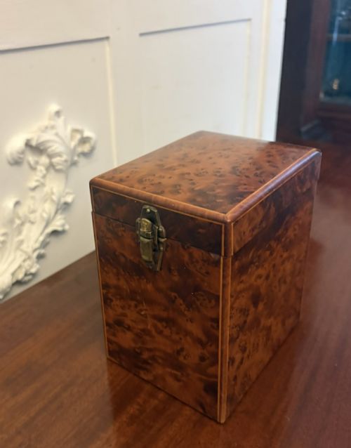 fig 5. An upright Victorian travelling tea caddy crafted from amboyna burl wood with line inlay and a brass front latch.