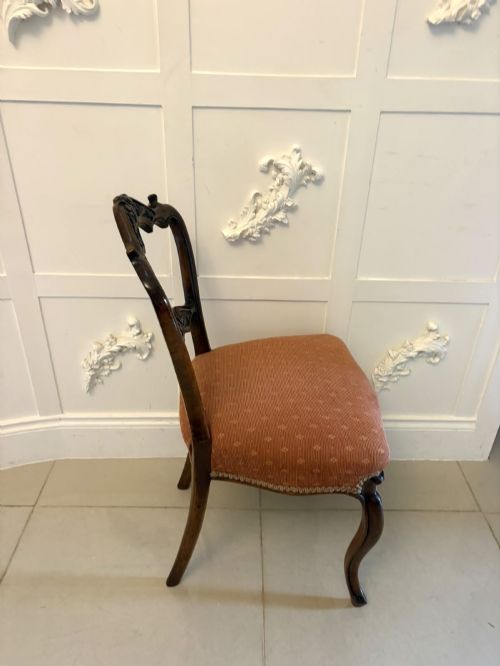 fig 5. A pair of Victorian carved walnut side chairs featuring open balloon backs with foliate carvings, cabriole legs, and terracotta patterned fabric upholstered seats.