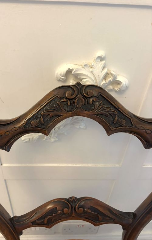 A pair of Victorian carved walnut side chairs featuring open balloon backs with foliate carvings, cabriole legs, and terracotta patterned fabric upholstered seats. View XIII