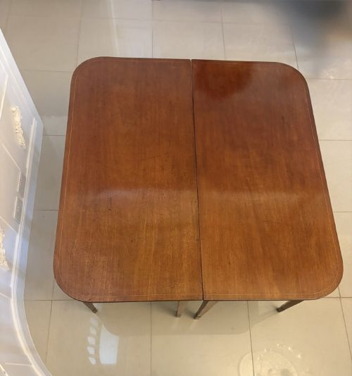 fig 1. A pair of Georgian mahogany console tables featuring rounded corners, inlaid aprons, and slender tapered legs.