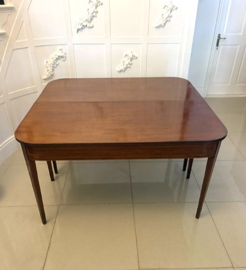 fig 4. A pair of Georgian mahogany console tables featuring rounded corners, inlaid aprons, and slender tapered legs.