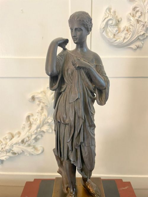 fig 2. A Regency bronze and marble clock set featuring a central figure-topped mantel clock flanked by a pair of three-branch candelabra.