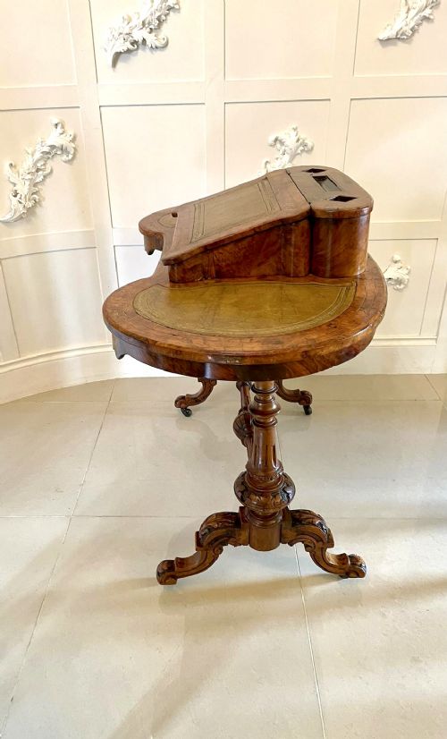 A Victorian burr walnut kidney-shaped writing table with floral marquetry inlay, green leather panels, and a central raised writing slope. View II