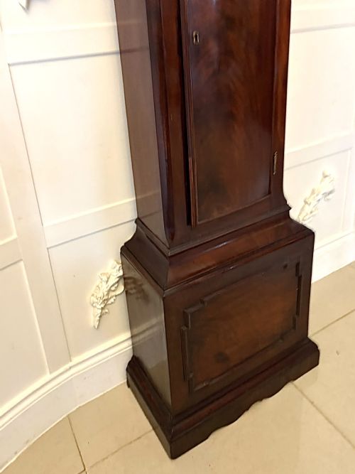 fig 7. An antique Georgian longcase grandfather clock crafted from flame mahogany wood with an arched brass dial and brass finials.
