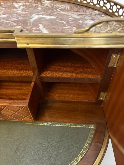 fig 6. A French kingwood parquetry bonheur du jour writing desk featuring a green leather inset, marble top gallery, and gilt-bronze mounts on slender cabriole legs.
