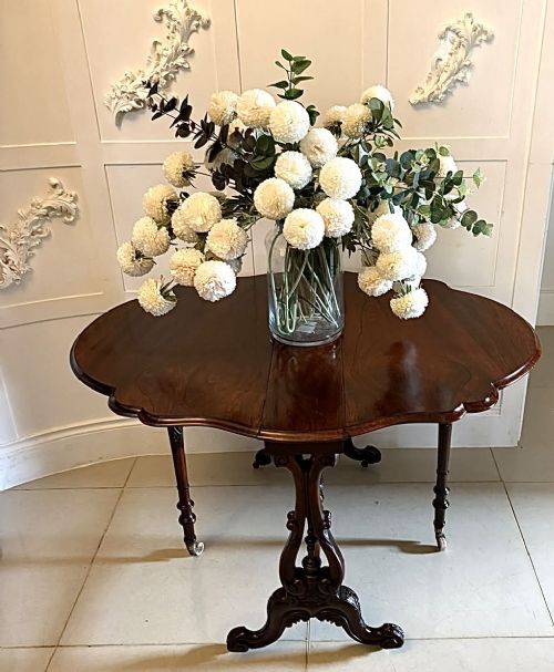 fig 1. An antique Victorian rosewood Sutherland table with drop leaves, carved legs, and brass castors.